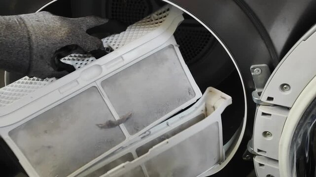 Dirty dryer filter filled with dust and lint after laundry cycle