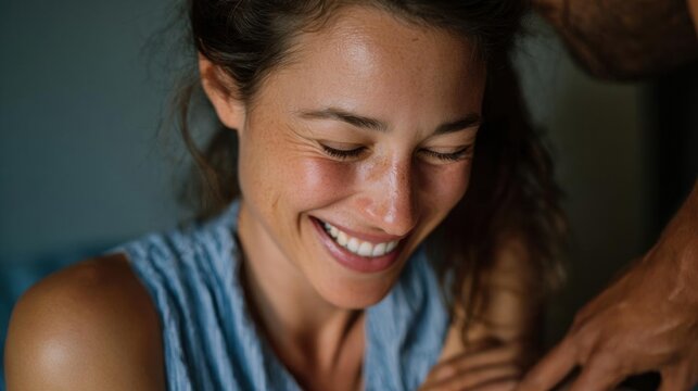 Close-up portrait of a young woman with a big smile on her face. she appears to be laughing or enjoying herself, with her eyes closed and her mouth slightly open.