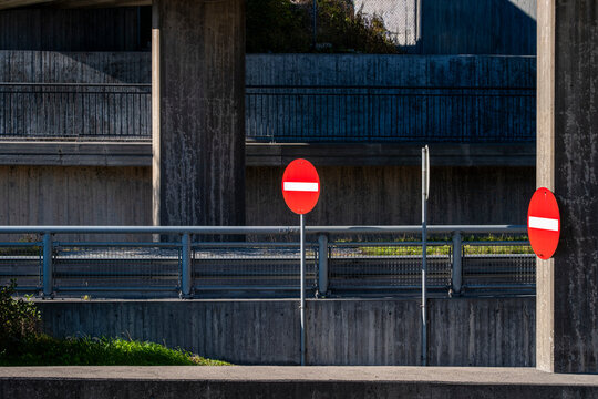 Highway overpass infrastructure with concrete barrier and sign showing prohibited entry in Stockholm Sweden for traffic safety on road
