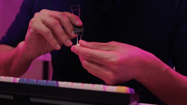 Keyboard modding scene. Closeup of key replacement in vibrant studio setting. Dynamic view of mechanical key modding process illuminated by bright pink studio lighting