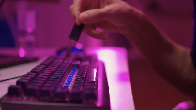 Removing and replacing keyboard keycaps. Detailed view of keycap swapping on keyboard. Vivid scene demonstrating removal and installation of keycaps on mechanical keyboard