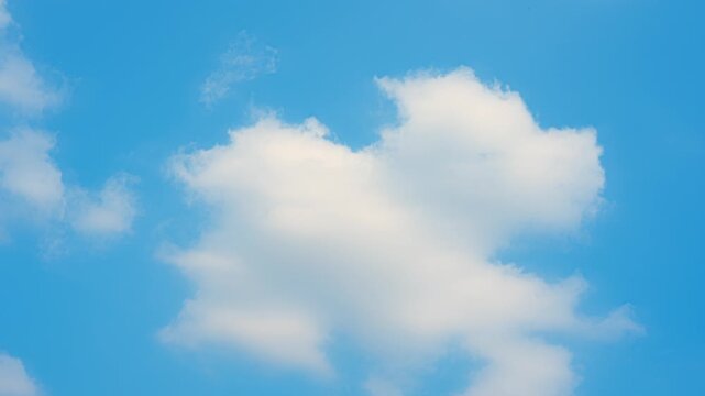 A blue sky timelapse video footage featuring isolated cumulus clouds drifting gently, highlighting soft, fluffy formations, clear atmospheric depth, smooth natural motion under bright daylight skies.
