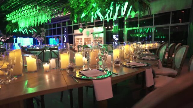 A sophisticated dining setup with candlelit tables and green ambient lighting. Perfect for event planning visuals or luxury venue promotions.