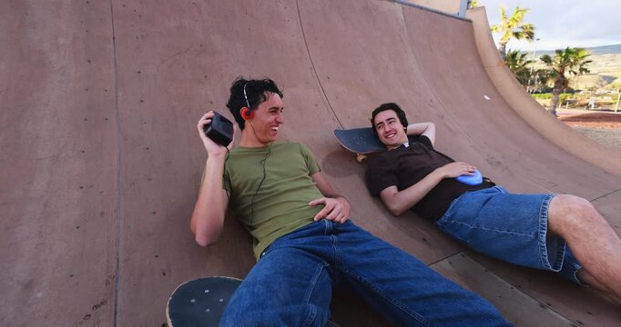 Two young friends listening music with cassette and cd player - 90's trend, people lifestyle and vintage analog devices - UGC wide lens content
