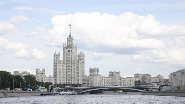 Moscow, Russia. - June 22, 2025: The Moscow River and in the distance a skyscraper on Kotelnicheskaya Embankment in the center of Moscow. River transport transports people.