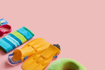 Summer composition with towel, flippers and headphones on pink background © Pixel-Shot