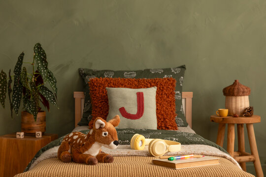 Cozy Children's Bedroom with Forest Theme Decor, Soft Green Walls, and Playful Accessories for a Comfortable Sleep Space