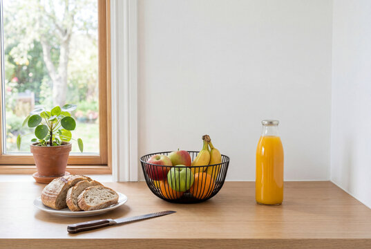 Breakfast Setup with Bread Fruit Bowl and Orange Juice by Window