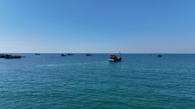 fishing boats pn calm sea with horizon and blue sky travel background