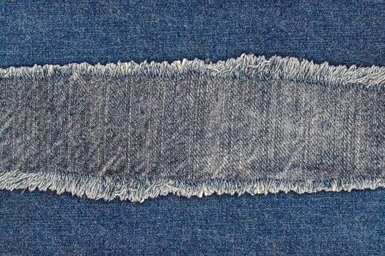 Ripped denim fabric showing texture and frayed edges in a bright setting