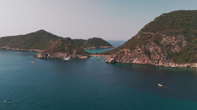 Aerial Flight Towards Porto Timoni Double Bay and Green Cliffs in Corfu Greece