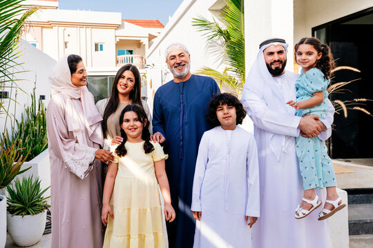 Arab family standing together outside modern home