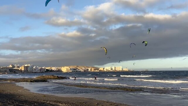 Kitesurfers on waves of Atlantic ocean in El Medano,Tenerife,Canary Islands,Spain. Kitesurfing, kiteboarding, kite surf. Extreme recreational water sport activity, summer fun adventure concept, 4K.
