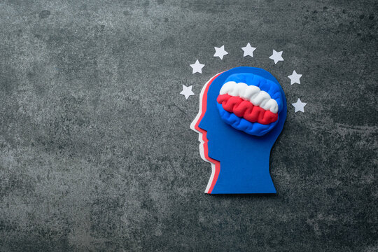 Creative concept of a head silhouette with a brain and stars around on a gray background. Concept American identity, unity, and the mindset of celebration during Independence Day. top view