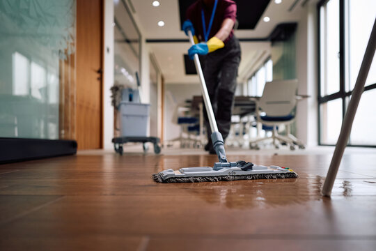 Close up of professional cleaner polishing floor surfaces with mop.