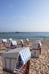 Fototapeta premium Strandkorb on Rugen beach with blue striped canopies and Baltic Sea pier
