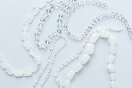 Many chains of rock crystal beads for jewelry, top view. Gemstones background