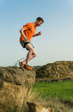 Man trail running jumping rock outdoors nature activity