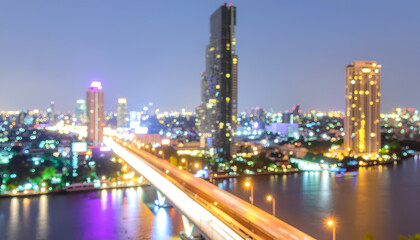 Naklejka premium Illuminated river bridge and modern skyline at night.