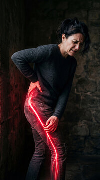 Woman suffering from severe hip and leg pain shown as a glowing red nerve path. Healthcare concept illustrating sciatica or injury. Medical diagnosis and treatment for chronic musculoskeletal ache.