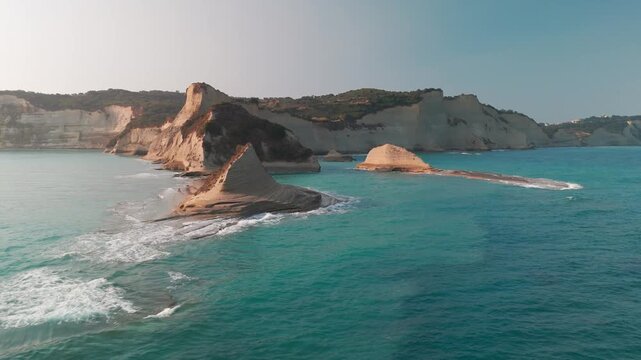 Aerial Sunrise Orbit of Cape Drastis Cliffs and Turquoise Sea Caves in Corfu Greece