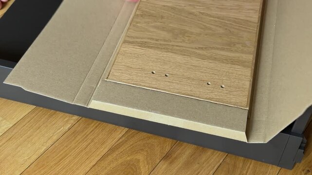 Wooden drawer front panel taken out of cardboard packaging close up