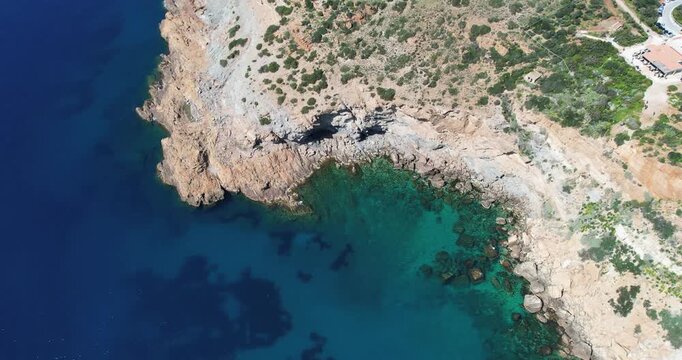 Ancient temple of Poseidon, Attica, Greece. Aerial drone bird eye view of archaeological site of Cape Sounion and magnificent deep blue bay with yachts docked