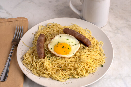 angel hair pasta  with fried egg and  breakfast sausages