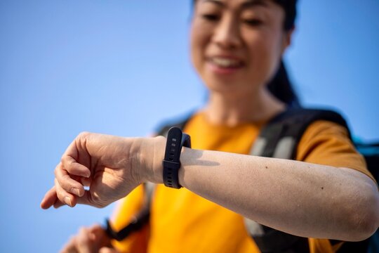 Close up of delivery worker checking smartwatch