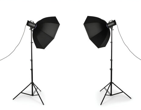 Professional studio strobe lights with umbrellas on stands isolated.