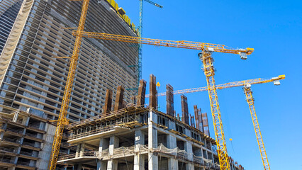 Tower cranes and modern structures rising during a large scale construction project, symbolizing continuous urban development, future growth, and ongoing engineering progress © Newleks