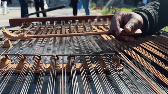 A street musician plays a cimbalom, very special string wooden musical instrument. The cimbalom, tambal, hammered dulcimer with player hands, hammers