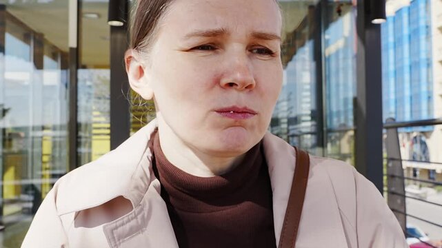 Woman tastes food outside store on bright day