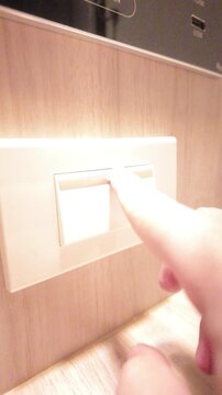 Slow motion of hand pressing a light switch to turn lights off in the bedroom. Concept of energy saving, power efficiency. 4K vertical resolution