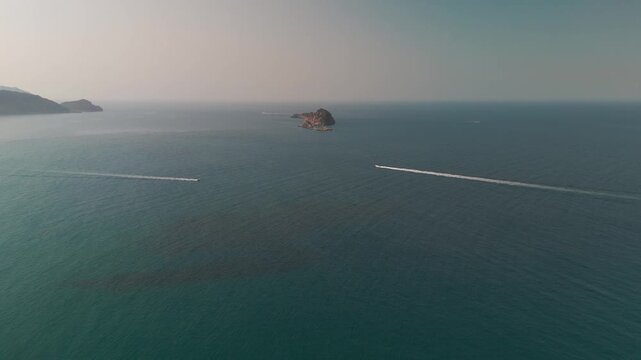 Aerial Descent of Speedboats in Arillas Bay Towards Karavi Island Rock Formation in Corfu Greece