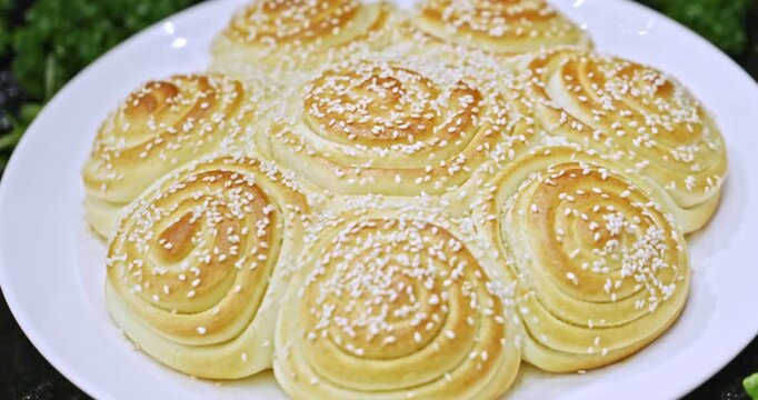 Flower-shaped baked buns with auspicious floral patterns, served on a white porcelain plate.