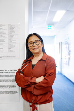 Doctor standing in clinic hallway with arms crossed