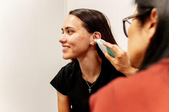 ENT doctor examining the patient with ear thermometer
