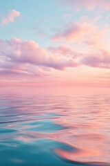 Obraz premium Pastel sunset over calm ocean water. Serene evening sky with soft pink clouds reflecting on the gentle sea surface. Natural background for meditation, relaxation and peace concept.