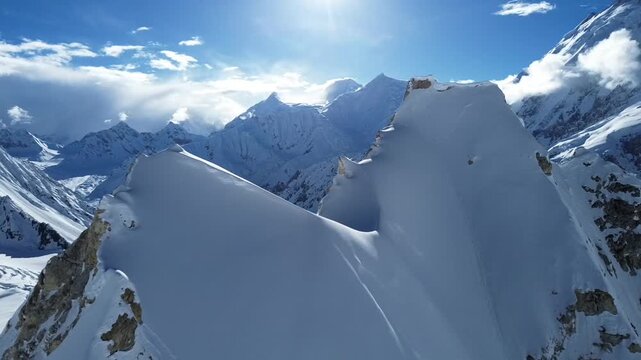 Cinematic Drone footage of a high-altitude mountain glacial landscape in the Karakoram Range, featuring snow-covered peaks with sun shining in clear blue sky