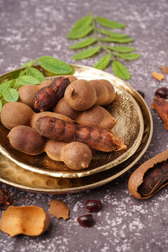 Plates of tasty tamarinds on grey background