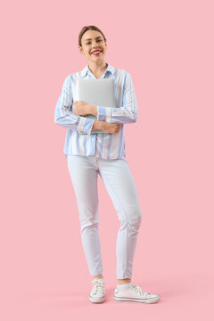 Female programmer with laptop on pink background