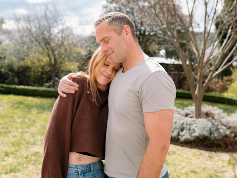 Father hugging teenage daughter in the garden