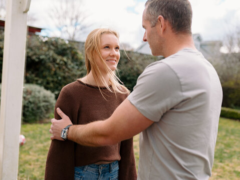 Father holding daughter on both arms while standing in the garden