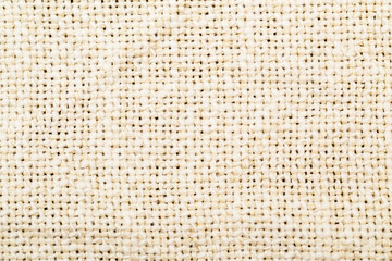 Close-up view of woven fabric showing texture and pattern in natural fibers on a plain background
