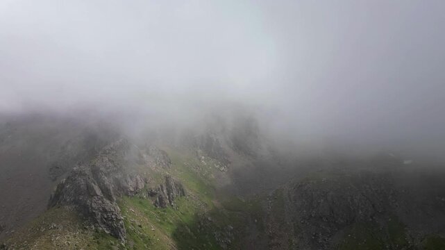Вариант 1: Thick fog and clouds rolling over mountain rocky peaks, time-lapse.