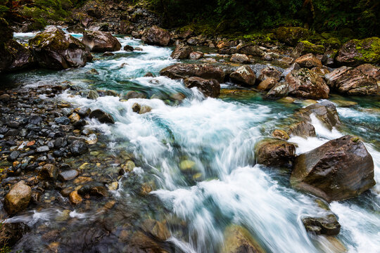 Rapids flowing over rocks in s shape bend with a slow shutter speed