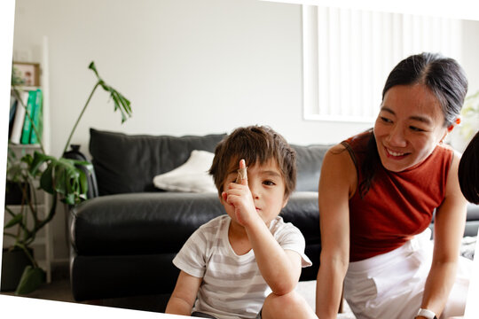 young boy sitting on the floor beside mum with Band-Aid paster on his finger