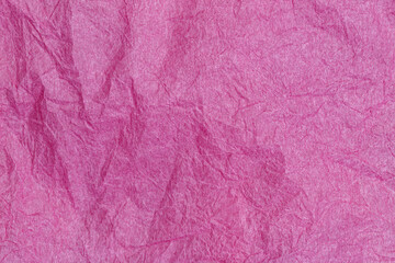 Fototapeta premium Texture of pink paper showing creases and folds in natural light on a simple surface