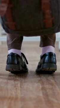 Anxiety, feet and student in high school for education, quiz stress and adhd for learning difficulty. Shoes, child and teenager with nervous tapping for exam worry, studying and space in classroom